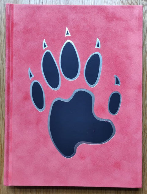 The photography book cover of At Home with the Furries by Tom Broadbent. Hardback in pink with a large paw on the cover.