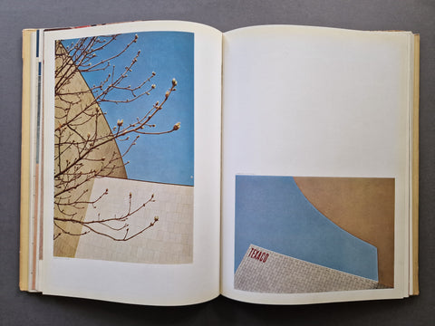 An open book spread showing two colour photographs - one of a tree on the left and one of a Texaco on the right