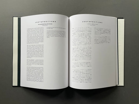 An open book with two white pages displaying black text, photographed from above on a dark gray background.