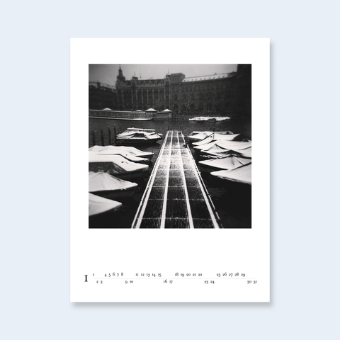 A minimalist calendar page featuring a central architectural photograph with a long perspective path.