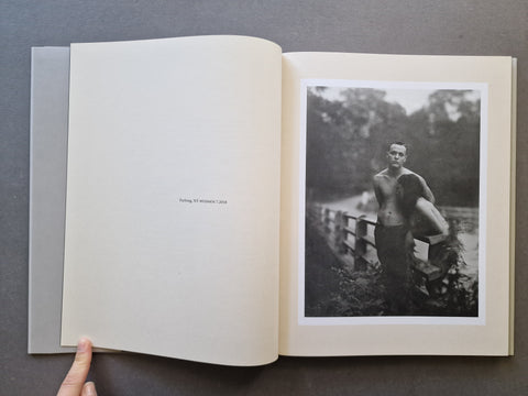 An open book, showing an off-white interior spread with a black-and-white vintage photograph printed on the right page. 