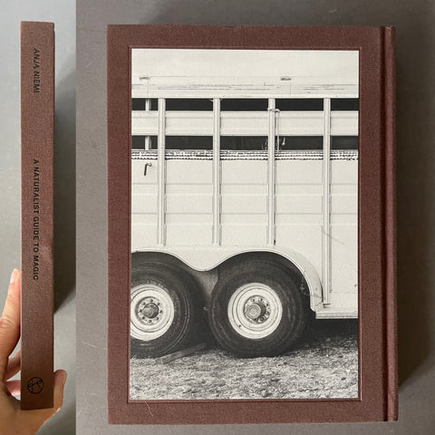 Back cover and spine of A Naturalist Guide to Magic by Anja Niemi with a horse trailer. 
