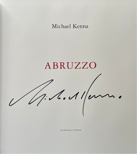 The front cover of the book 'Abruzzo' by Michael Kenna, published by Nazareli Press. The cover is white with the title in red serif font and a black ink signature of the author, Michael Kenna, printed below.