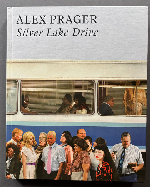 The front cover of the book 'Silver Lake Drive' by Alex Prager, featuring a large white top section with black text and a photographic lower section showing a crowd in front of a blue and cream train.