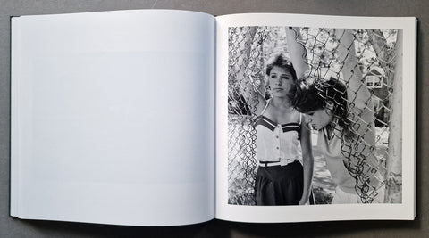 An open book, showing a black-and-white printed photograph on the right page with a mostly blank white left page.
