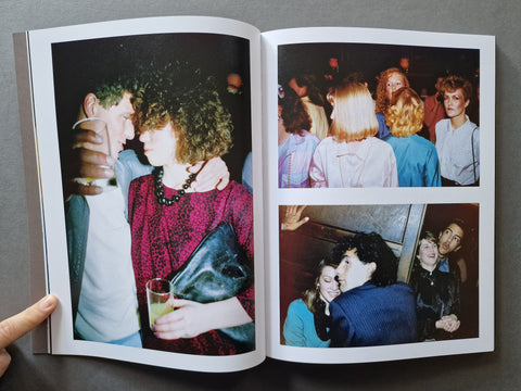 An open photo book, showing two printed pages with vintage-style photographs of people in social settings. 