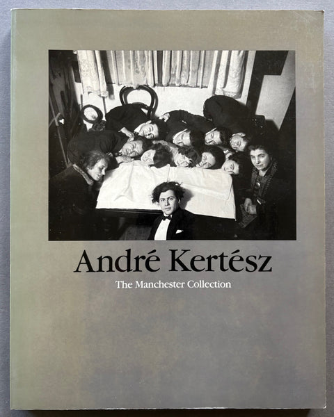 Book titled 'The Manchester Collection' by Andre Kertesz with a grey cover featuring people surrounding a table.