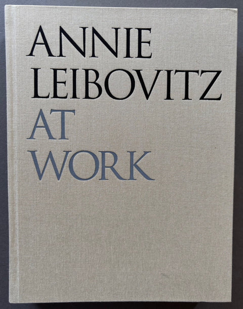 Book titled 'Annie Leibovitz At Work' with a beige cloth cover.