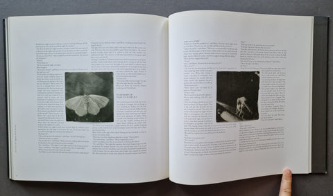 An open book showing two printed pages with columns of text and small black-and-white inset photographs.