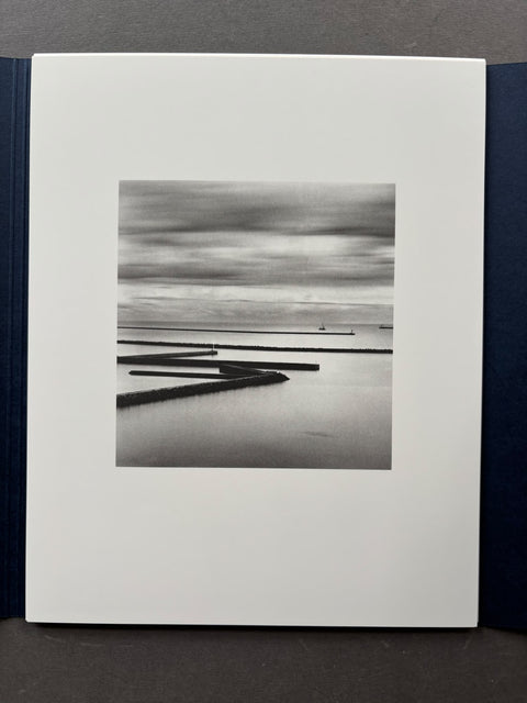 A black and white landscape photograph of a body of water