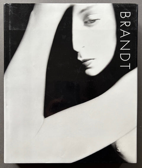 Book titled 'Brandt: The Photography of Bill Brandt with a black and white cover featuring the image of a naked woman.