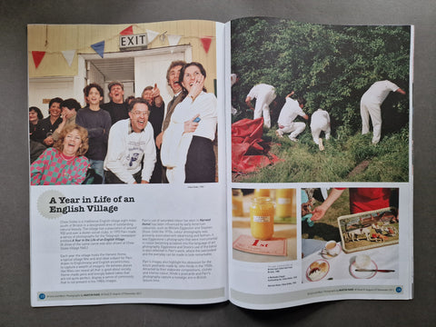 An open magazine spread photographed from above on a dark gray surface. The pages contain multiple photos: a group of people smiling outdoors on the left, people gardening on the right, and small food/drink photos at the bottom.