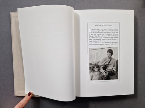 An open book, showing blank white pages on the left and a printed text page with a small black-and-white photo on the right.