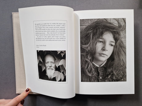 An open book, showing two printed pages with text and black-and-white portraits. 