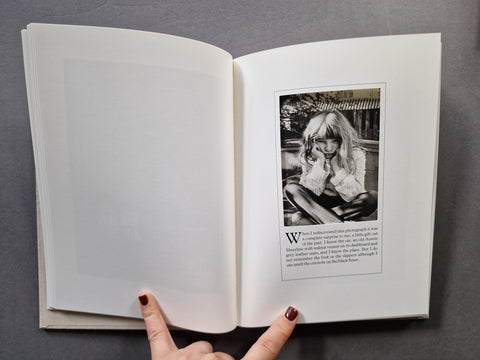 An open book: The right page shows a black-and-white portrait photograph of a young girl with text below it.