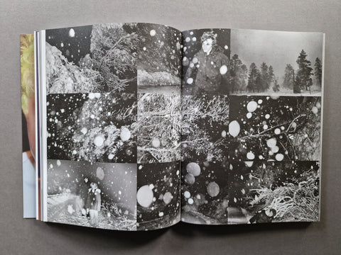 An open book, showing a black-and-white collage of snowy forest scenes and a person in one of the panels.