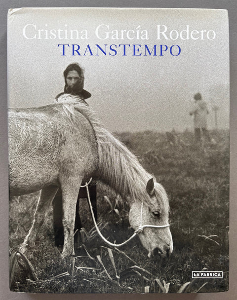 Book titled Transtempo by Cristina Garcia Rodero with a dust jacket featuring a black and white image of a woman standing behind a white horse.