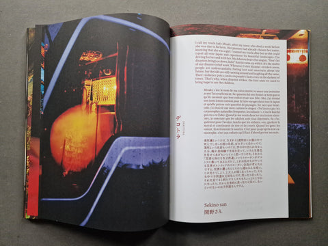 An open book, showing a large black-and-orange photograph on the left page and columns of text on the right page.