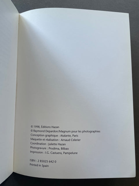 An open book showing the blank white interior page with printed publication credits in French, including © 1998, Éditions Hazan and ISBN 2 83025 642 0, photographed against a dark background.