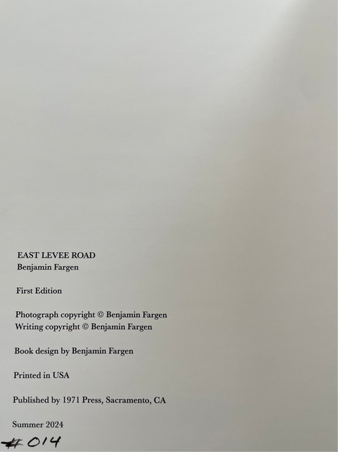 A close-up of a book's printed title and copyright page, showing the title 'EAST LEVEE ROAD' by Benjamin Fargen, with publication details and a handwritten number '014' at the bottom left.