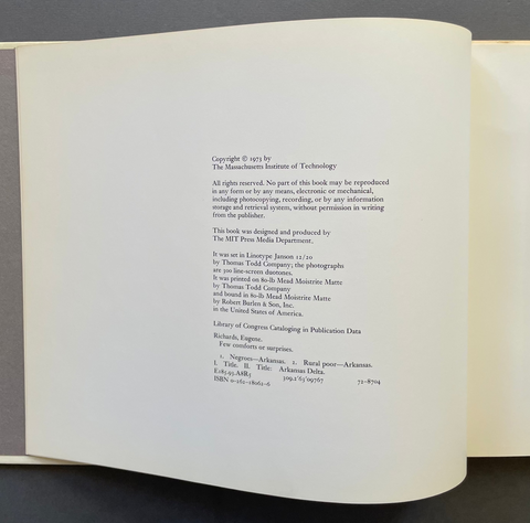 An open book spread showing printed copyright text on cream pages against a dark gray background.