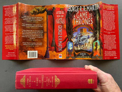 Book titled 'Game of Thrones: A Sing of Ice and Fire' by George R. R. Martin with a cover featuring the image of a castle and a knight on horseback.