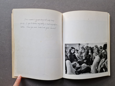 An open book, showing handwritten text on the left page and a black-and-white photograph on the right page. 