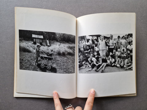 An open vintage book, showing two black-and-white printed photographs on the pages. 