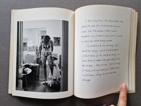 An open book showing a black-and-white photograph of a woman in a room on the left page and handwritten text on the right page.