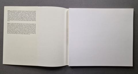 An open book, showing a single-page text layout on the left page and a blank white page on the right.