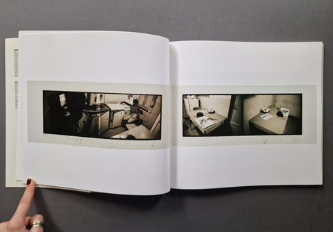 An open book, showing two interior scene photographs printed on white pages.