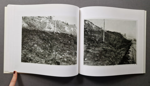 An open book showing two black-and-white landscape photographs printed on white pages