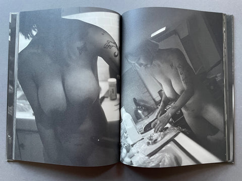 Open book showing black and white images of a person in a bathroom.