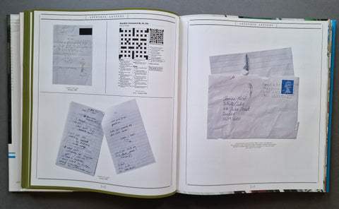 An open book showing printed pages with handwritten letters, a crossword puzzle, and postage stamp images on white paper.
