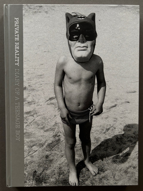 Book titled 'Private Reality: Diary of a Teenage Boy' by Iain McKell with a cover featuring a black and white image of a boy on a beach wearing a Batman mask.