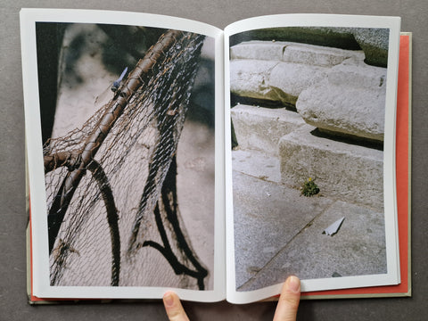 An open book showing two printed photographs spread open on a dark gray surface. 