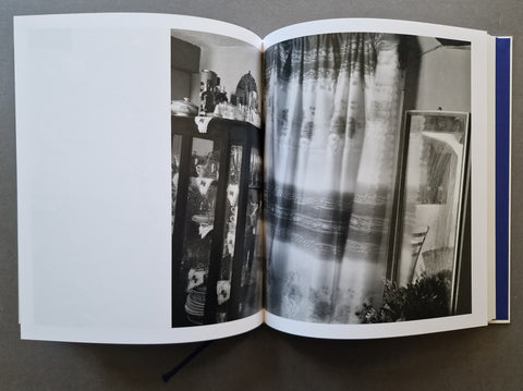 An open hardcover book, showing a black and white photo of an interior
