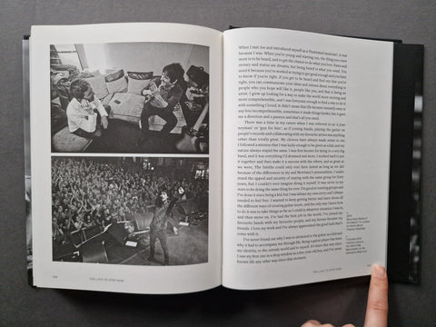 An open book showing two black-and-white photographs on the left page and columns of text on the right, photographed from above on a dark surface. 