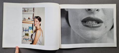 An open book, showing two printed pages. The left page contains a small vertical color photo of a woman standing in front of shelves, and the right page shows a large black-and-white close-up of a woman's mouth and lower face.