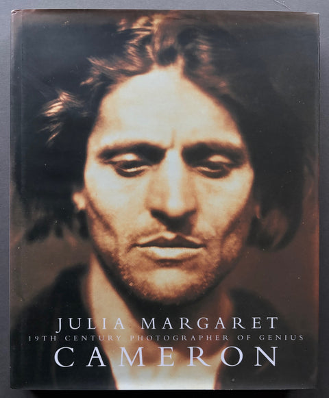 Book titled 'Julia Margaret Cameron: 19th Century Photographer of Genius' with a cover featuring a close up image of Charles Darwin.