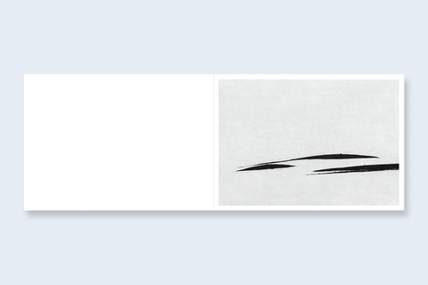A book spread featuring a large blank white left panel and a textured light gray landscape on the right with two black hill outlines.