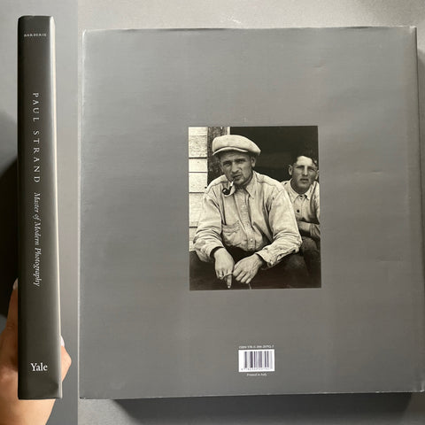 A hardcover book titled 'Paul Strand: Master of Modern Photography' held upright next to its back cover, which is gray and features a black-and-white portrait photograph in the center. The Yale publisher mark is visible at the bottom.