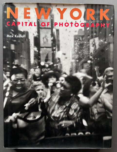 Book titled 'New York: Capital of Photography' by Max Kozloff with a black and white cover of people in Times Square.