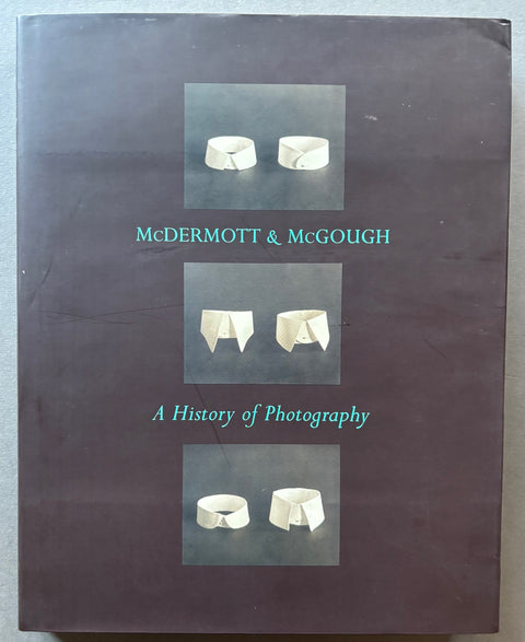 Book titled 'McDermott & McGough: A History of Photography' by Mark Alice Durant with a black cover featuring 3 images of white collars.