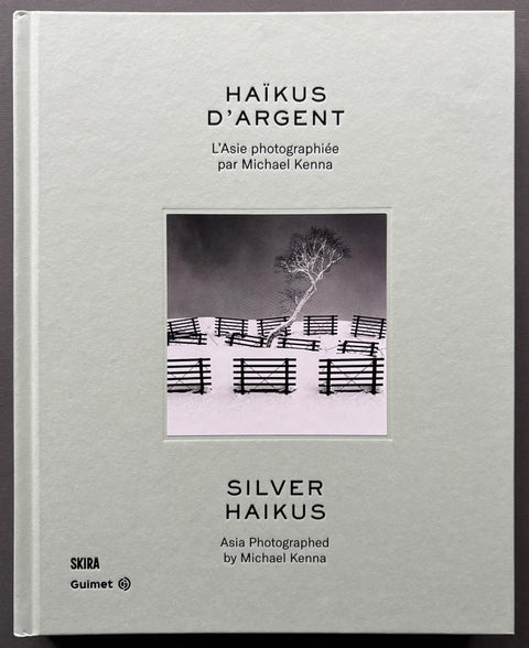 Book titled 'Silver Haikus' by Michael Kenna with a grey cover featuring the image of a tree surrounded by snow and fence panels.