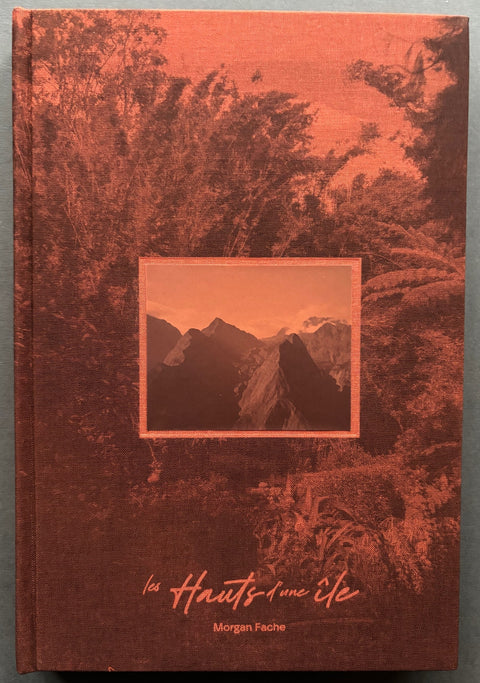 Book titled 'les hauts d'une ile - The Heights of an Island' by Morgan Fache with a red cover featuring the image of a range of mountains.