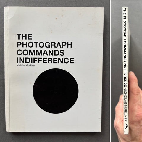 Book titled 'The Photograph Commands Indifference' by Nicholas Muellner with a white cover and a large black circle.