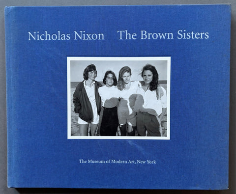 Book titled 'The Brown Sisters' by Nicholas Nixon with a blue cover featuring a black and white image of Nixon's wife and her 3 sisters.
