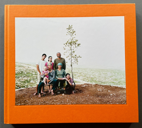 Book cover of the 'Settlement' by Nick Waplington with a color photo of a family on top of a hill. 