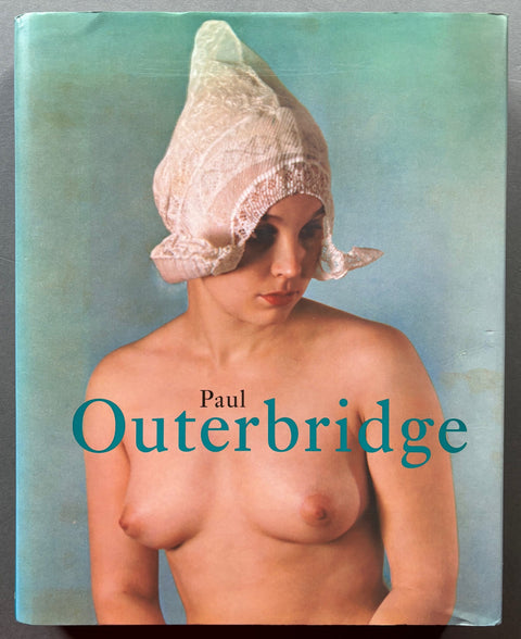 Book titled 'Paul Outerbridge' by Paul Outerbridge with a cover featuring the image of a woman naked from the waist up and wearing a Dutch cap.